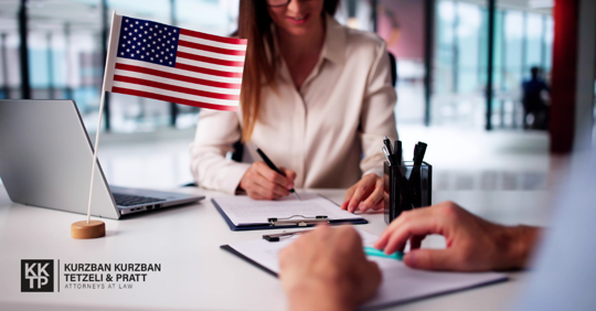 person at desk filing out visa papers with American flag nearby